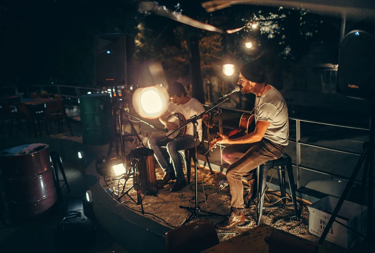 Künstler auf einer Bühne während einer Live-Musikaufführung bei Nacht