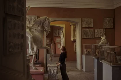 Besucher in beleuchteten Museumsgalerien bei Nacht, Silhouetten vor Kunstinstallationen