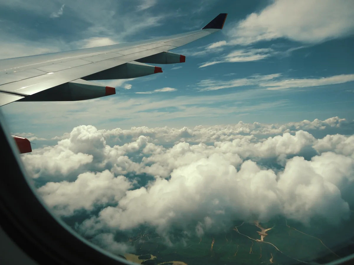 Luxuriose Flugzeugkabine mit Fensterblick auf Wolken und leeren Sitzen