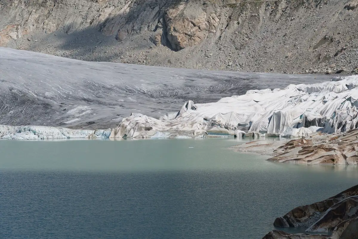 Schmelzender Gletscher mit Moränenschutt und Gletschersee