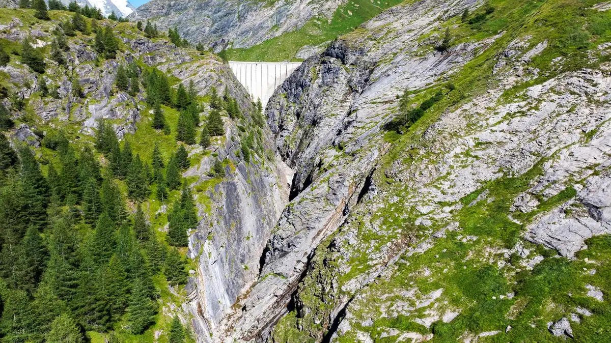 Gletschersee hinter Moränendamm in Berglandschaft mit drohenden Wolken