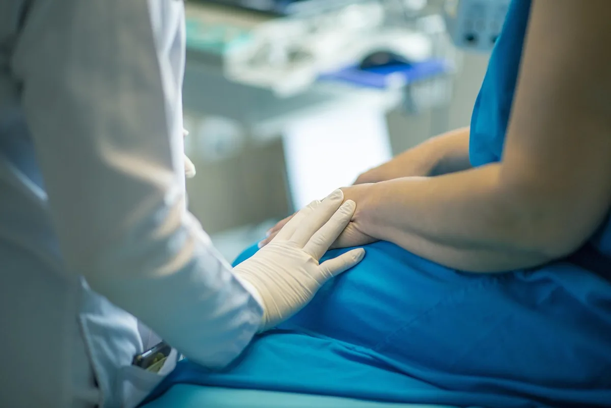 Arzt und Patient mit Informationsblatt über Impfungen in einer Praxis