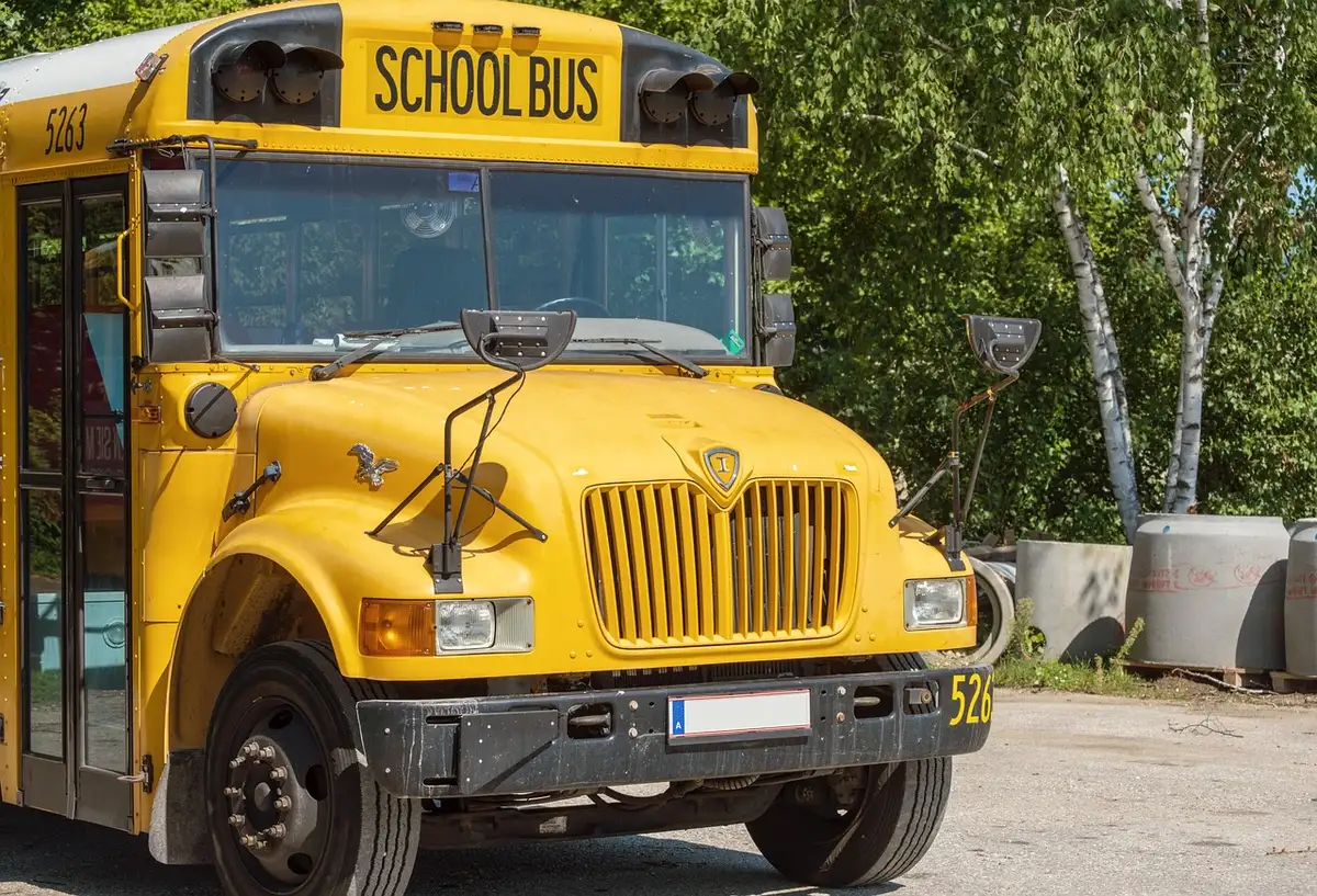Schüler steigen in einen Schulbus ein oder fahren darin