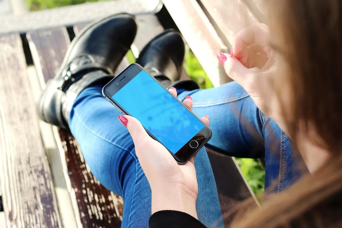 Seniorin erhält eine Warnmeldung auf dem Smartphone, barrierefreie Information