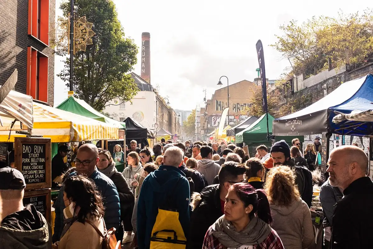 Dichter belegter Wochenmarkt mit Verkaufsständen und Besuchern