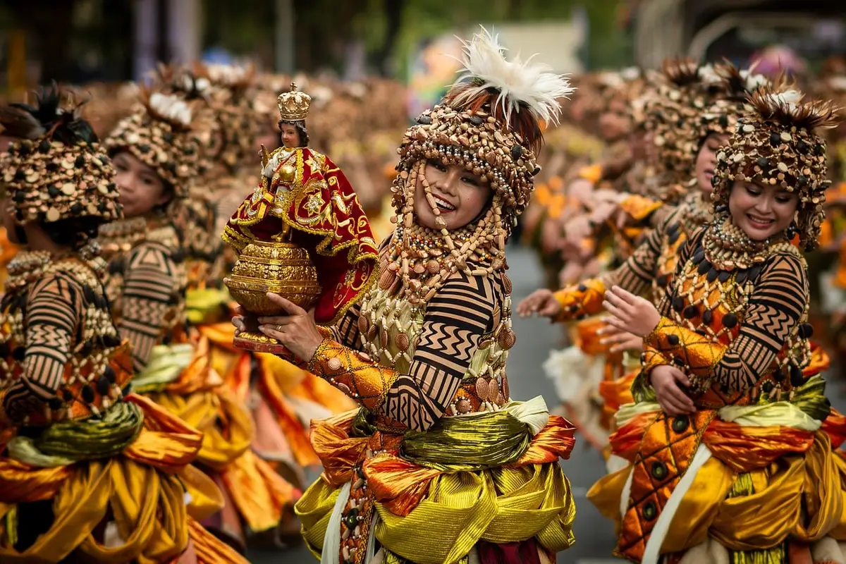 Große Menschenmenge bei einer Straßenparade mit Bühnen und Pavillons
