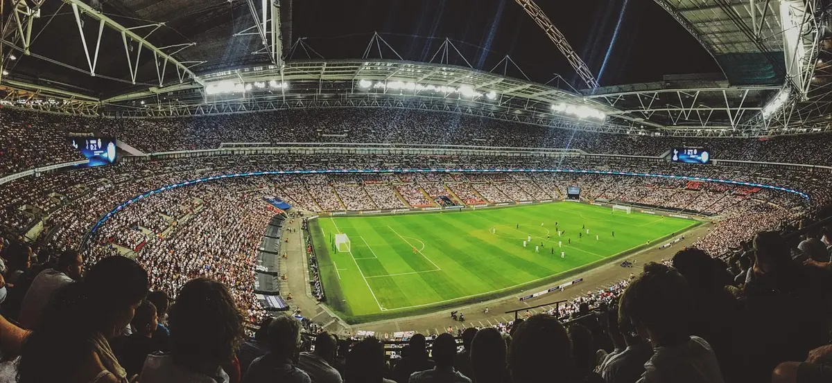 Moderatoren und Übertragungsbildschirm im TV-Studio bei Fußballübertragung