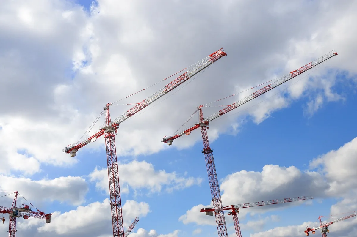 Baustelle eines Stadions neben Wohngebäuden als Symbol für städtebauliche Folgen