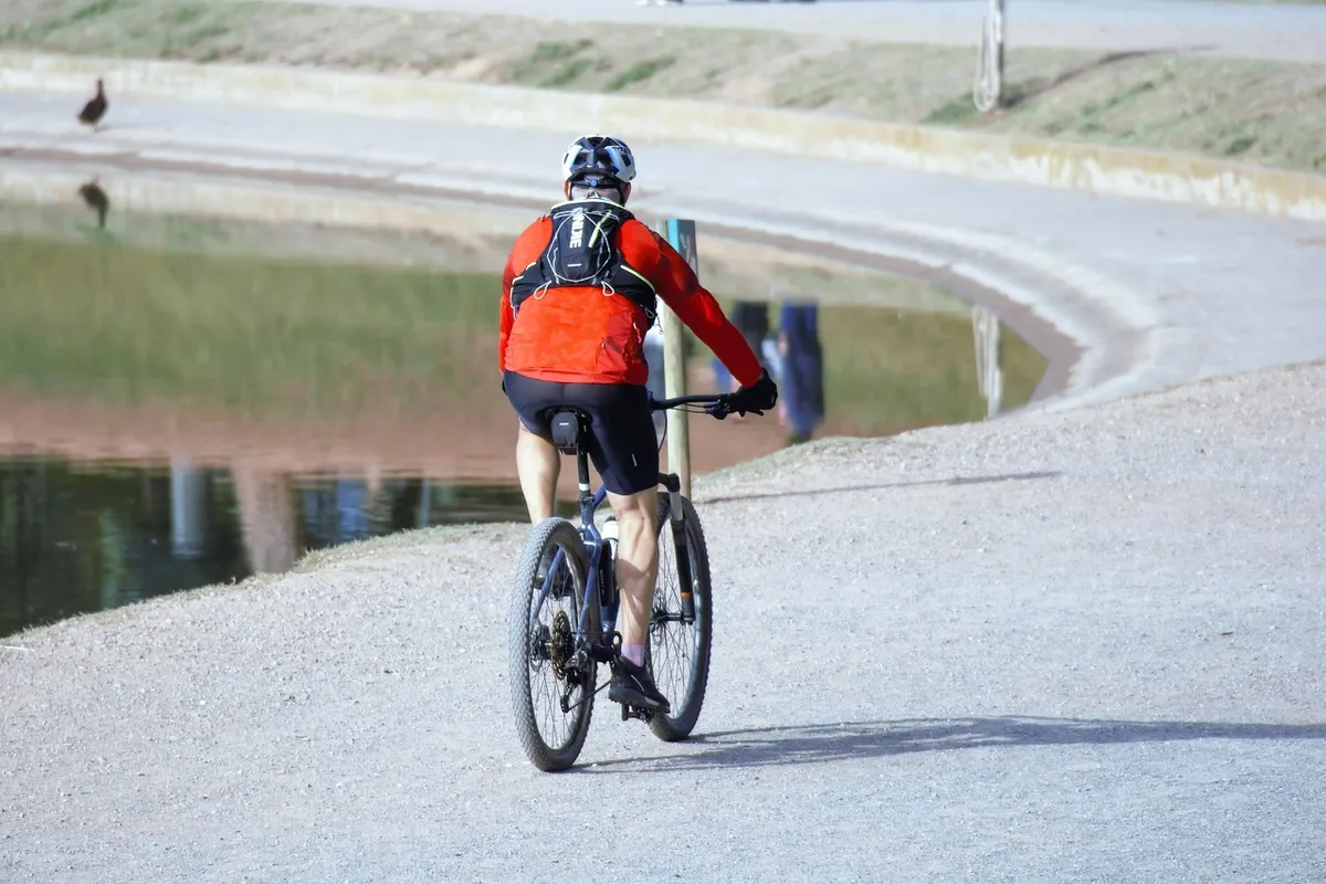 Radfahrer trinkt während der Fahrt in der heißen Stadt