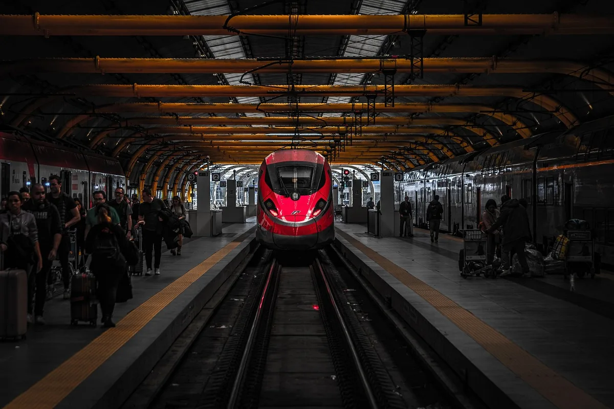 Digitale Auslastungsanzeige auf einem Bahnsteig neben wartenden Fahrgästen