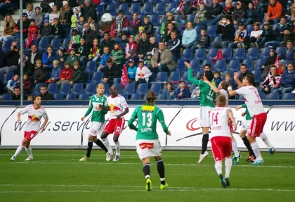 Anonyme Fangruppen mit Schals und ein Trainingsball vor einem Clipboard in einer Stadionumgebung