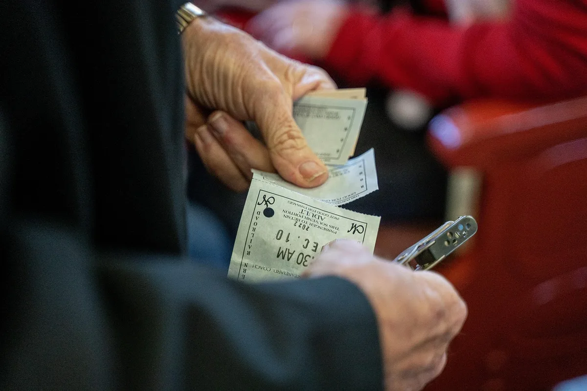Fahrkartenautomat und Hände beim Kauf eines Tickets