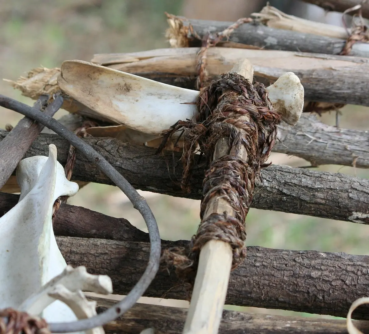 Innenansicht eines trockenen Brunnenbodens mit verstreuten Knochen und Keramik, Hand mit Kelle im Vordergrund