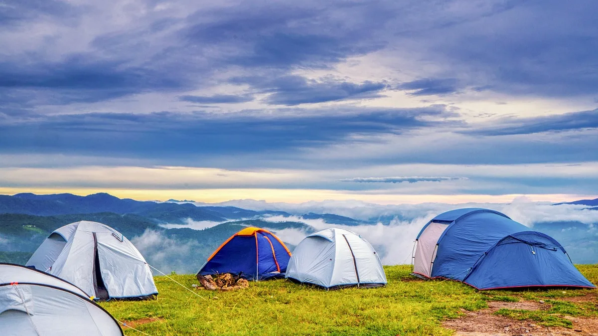 Ranger vor einem Campingplatz mit Hinweisschild zur Sperrstunde