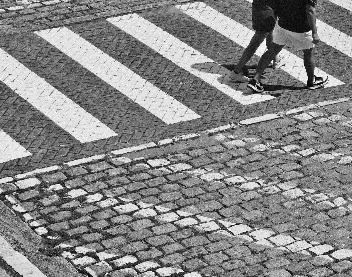 Gitarre und Akkordeon auf gepflastertem Platz, zwei anonyme Musiker im Hintergrund