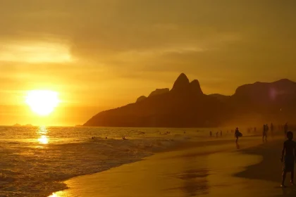 Keramikurne im Sand an einer ruhigen Strandbucht, entfernte Silhouette einer Person