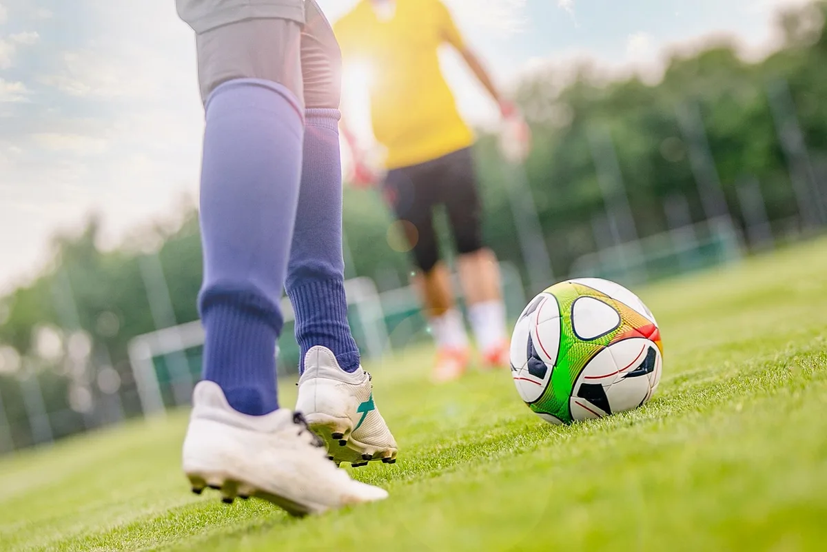 Trainer oder Betreuer spricht mit Torwart am Spielfeldrand