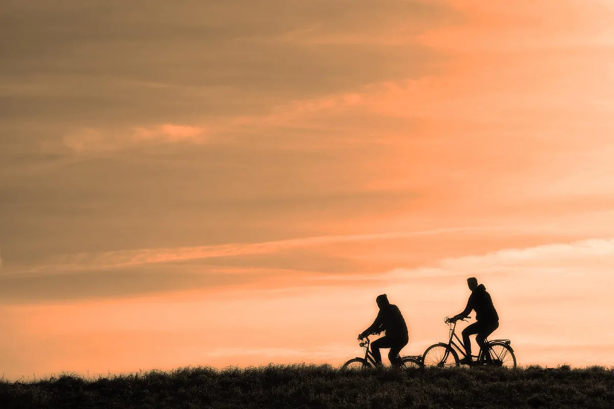 Person mit Fahrrad und Karte an einem Feldweg, symbolisch für kurze Ausflüge