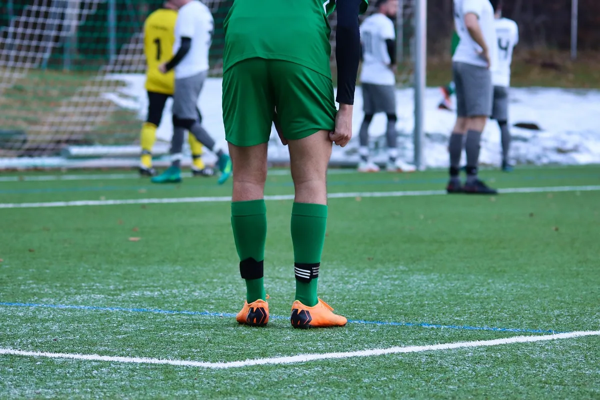 Trainer im Kreis mit Spielern vor einem Amateurspiel auf dem Vereinsgelände