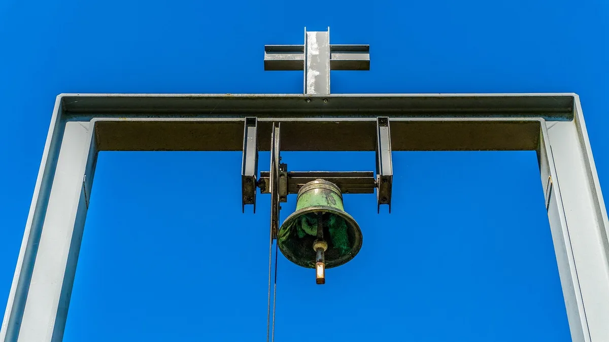 Detailaufnahme einer achteckigen Turmspitze mit allegorischen Figuren in einem historischen Monument
