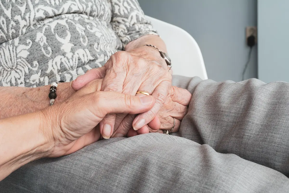Seniorin am Telefon, Notizen und Angehöriger neben ihr