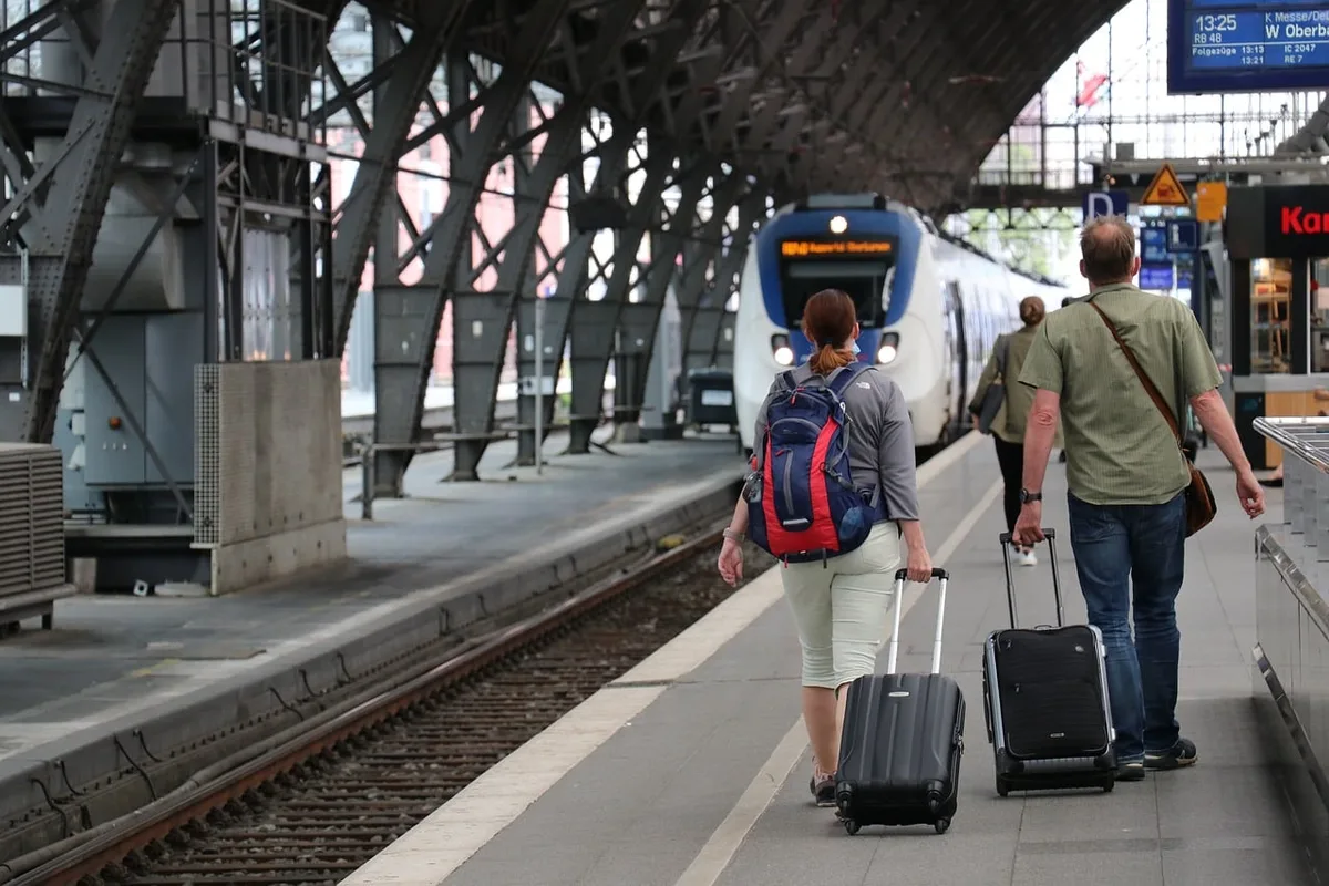 Fahrgast prüft Fahrplan‑App auf dem Bahnsteig
