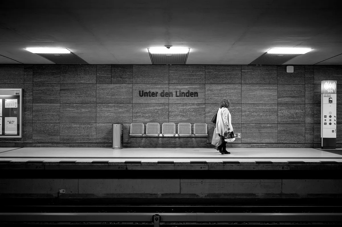 Silhouetten von Rucksäcken und Laptops auf einer Bank vor dem Berliner Stadtbild